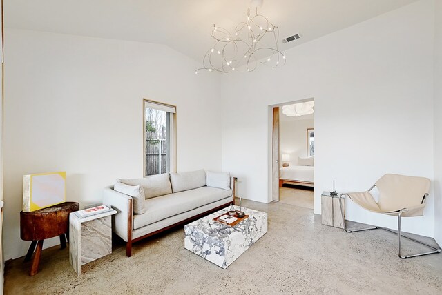 living room with a notable chandelier and lofted ceiling