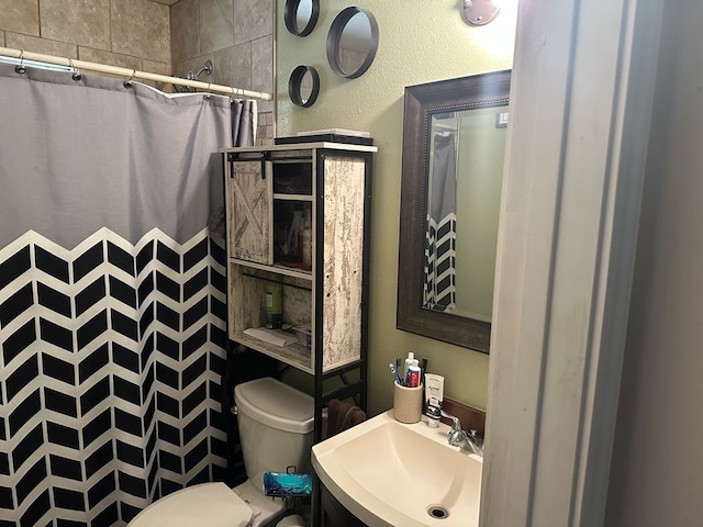 bathroom with toilet, sink, and walk in shower