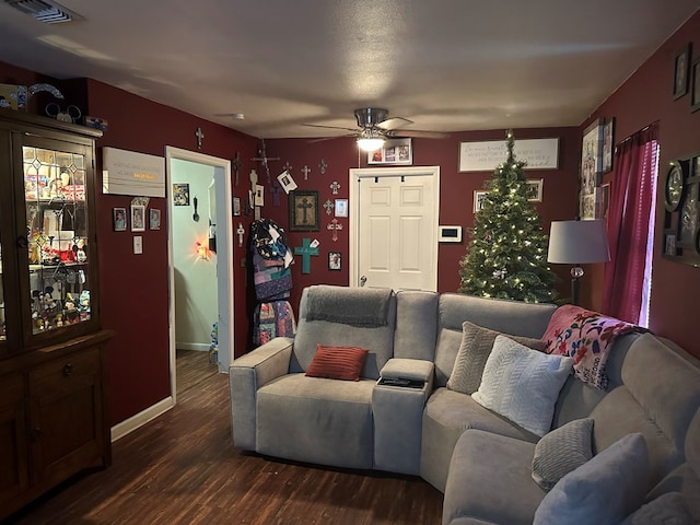 living room featuring ceiling fan and dark hardwood / wood-style flooring