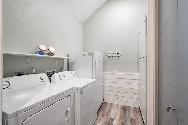 laundry area with washing machine and dryer and light wood-type flooring