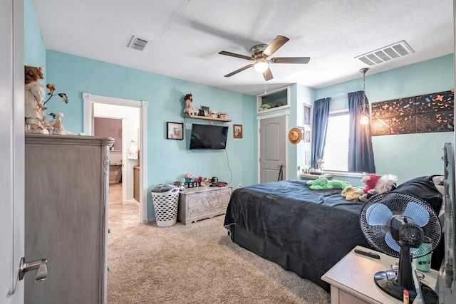 bedroom with a textured ceiling, light colored carpet, and ceiling fan