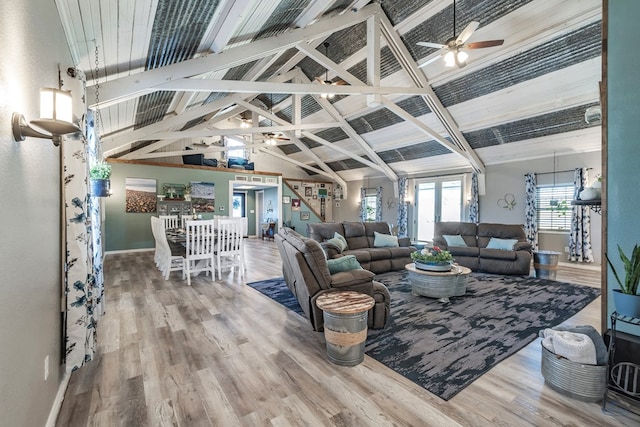 living room with hardwood / wood-style floors, ceiling fan, beamed ceiling, and high vaulted ceiling