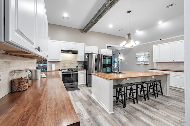 kitchen featuring light wood-type flooring, stainless steel appliances, white cabinetry, and butcher block counters