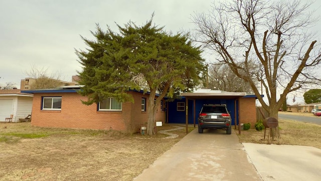 view of home's exterior with a carport, concrete driveway, and brick siding