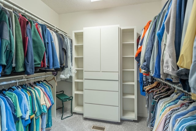 walk in closet featuring light carpet