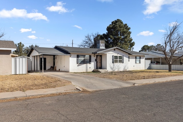 single story home with a carport, fence, driveway, and stucco siding