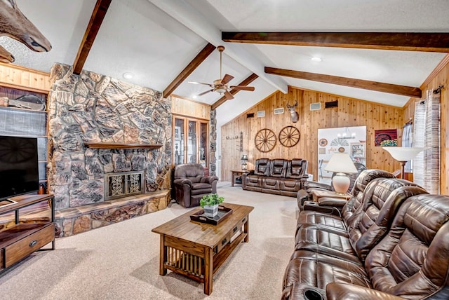 living room featuring carpet flooring, lofted ceiling with beams, a textured ceiling, a stone fireplace, and wood walls