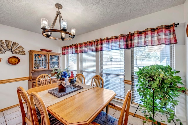 dining room featuring light tile patterned flooring, a textured ceiling, and a notable chandelier