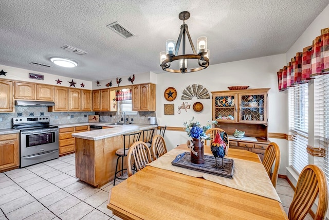 kitchen featuring sink, an inviting chandelier, decorative light fixtures, stainless steel electric range, and kitchen peninsula