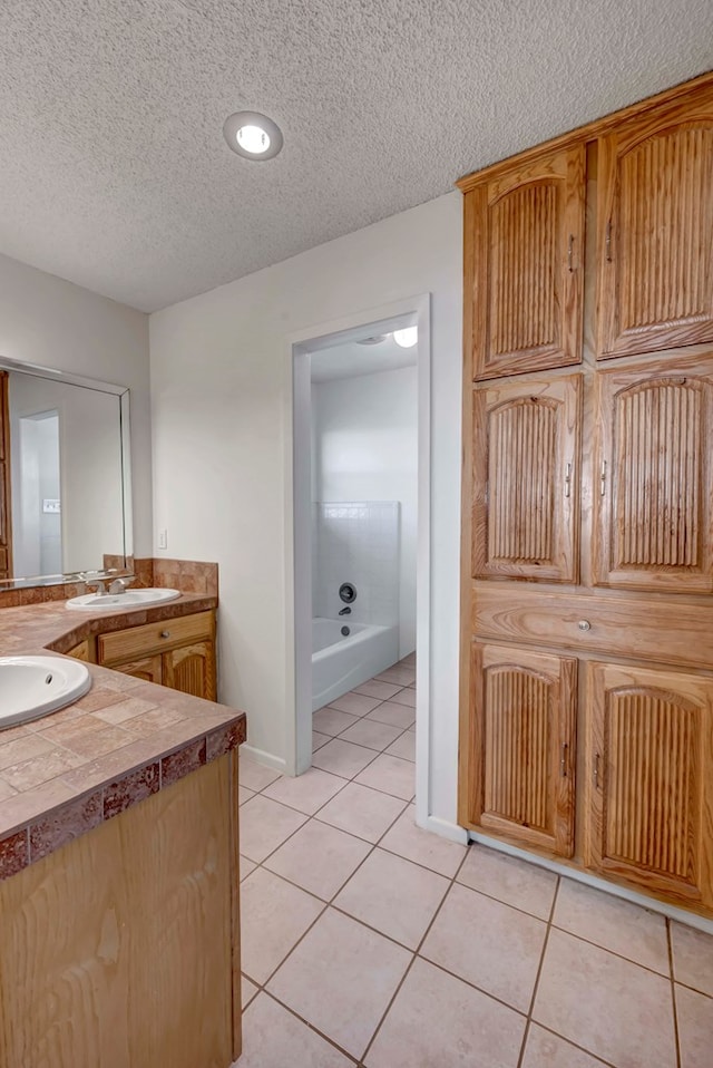 bathroom with tile patterned floors, vanity, and a textured ceiling