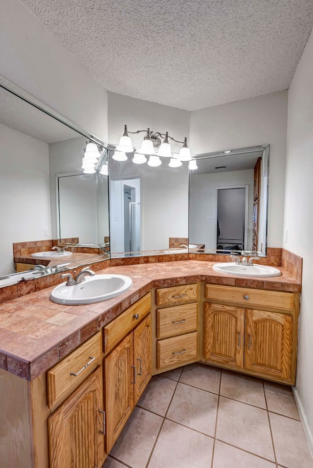 bathroom featuring vanity, tile patterned floors, and a textured ceiling