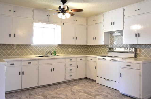 kitchen with sink, a textured ceiling, tasteful backsplash, white range with electric stovetop, and white cabinetry