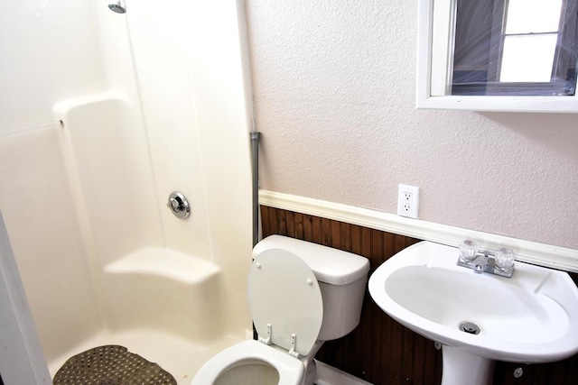 bathroom featuring a shower, toilet, and sink