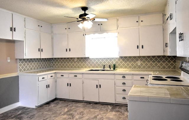 kitchen with white cabinets, white range with electric stovetop, sink, and tile countertops