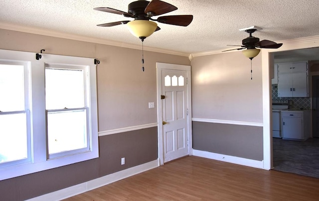 entrance foyer with a textured ceiling, hardwood / wood-style flooring, ceiling fan, and ornamental molding