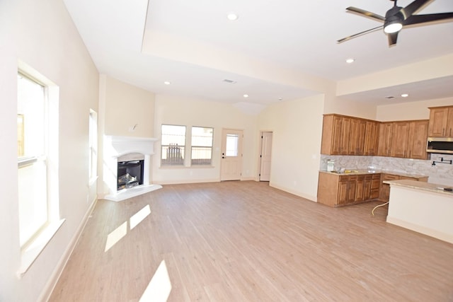 unfurnished living room with ceiling fan and light hardwood / wood-style floors