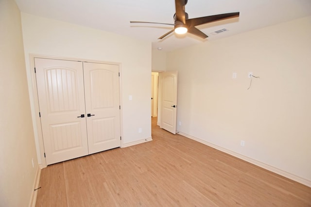 unfurnished bedroom featuring a closet, light hardwood / wood-style flooring, and ceiling fan