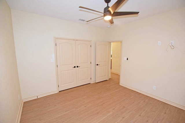 unfurnished bedroom featuring ceiling fan, a closet, and light hardwood / wood-style flooring