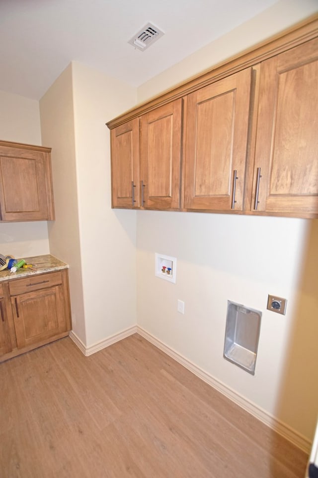 washroom with cabinets, washer hookup, light hardwood / wood-style flooring, and electric dryer hookup