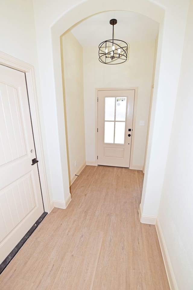 entryway with light hardwood / wood-style flooring and a chandelier