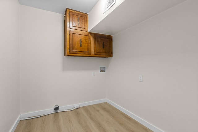 clothes washing area featuring cabinets, hookup for a washing machine, and light hardwood / wood-style flooring