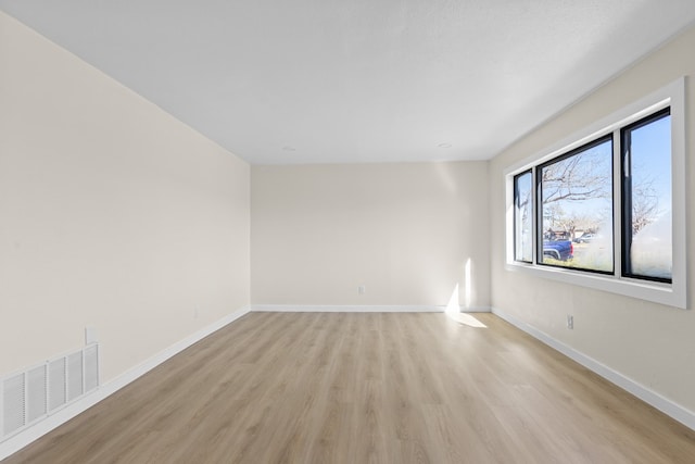 empty room with light hardwood / wood-style flooring