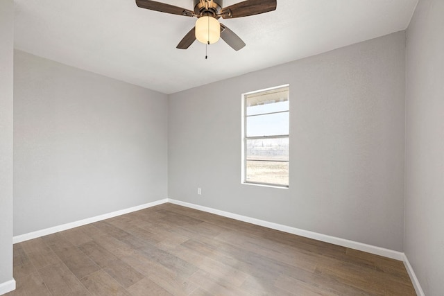 unfurnished room featuring ceiling fan, baseboards, and wood finished floors