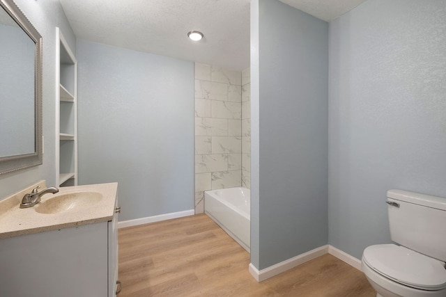 full bathroom with baseboards, toilet, shower / tub combination, wood finished floors, and vanity