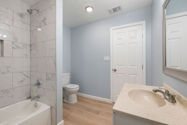 bathroom featuring bathtub / shower combination, toilet, wood finished floors, visible vents, and baseboards