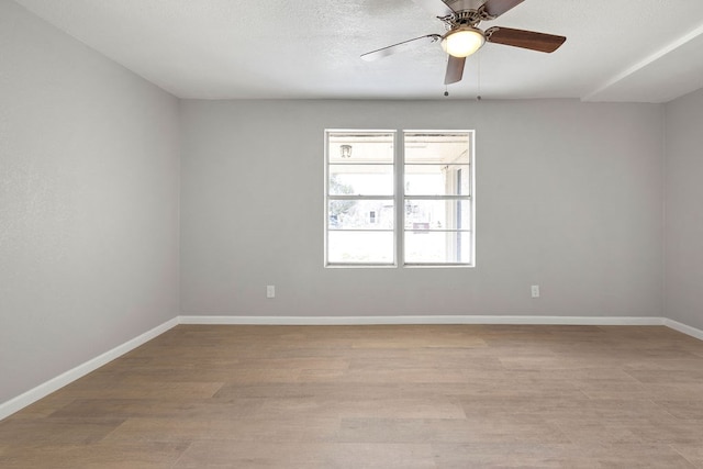 unfurnished room featuring light wood-type flooring, a ceiling fan, and baseboards