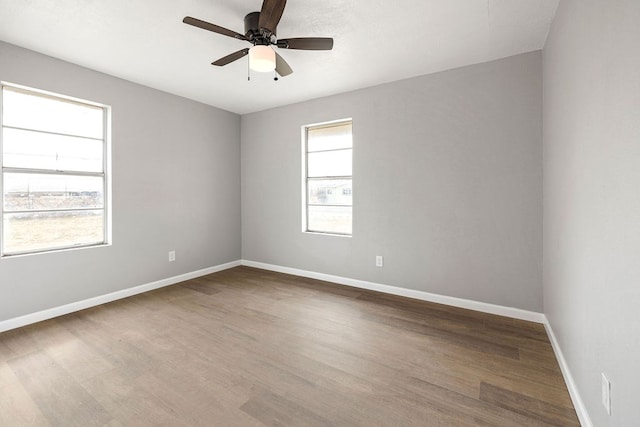 spare room with ceiling fan, wood finished floors, and baseboards