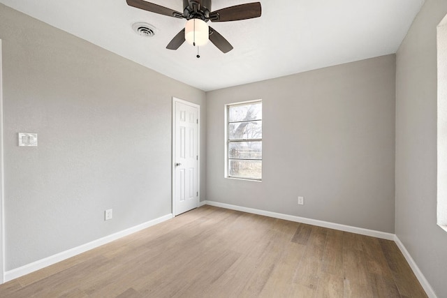 unfurnished room featuring a ceiling fan, light wood-type flooring, visible vents, and baseboards