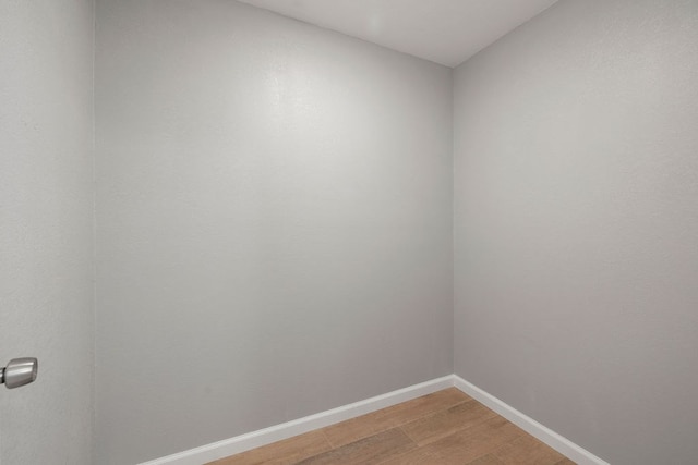 empty room featuring wood finished floors and baseboards