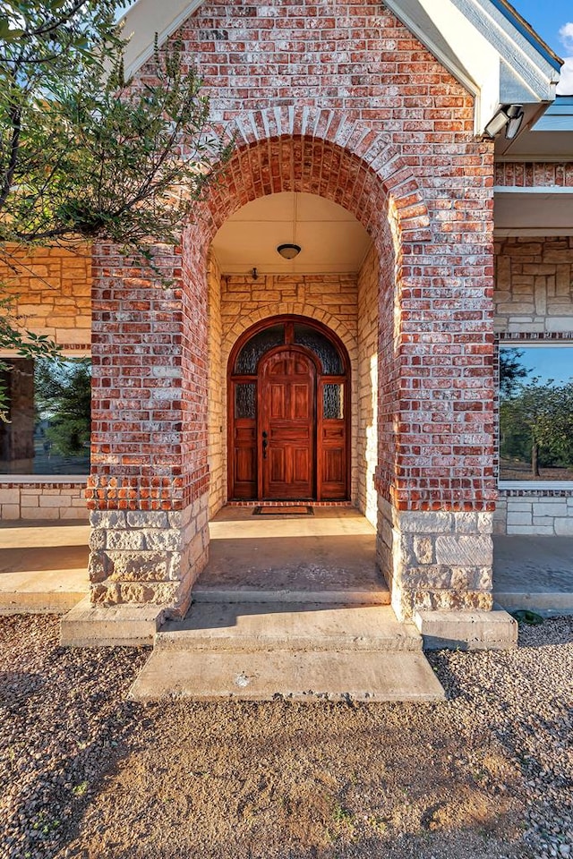 entrance to property featuring brick siding