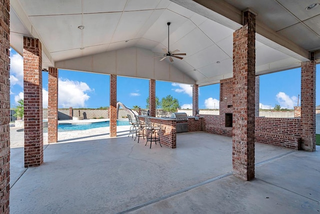 view of patio / terrace with a fenced in pool, ceiling fan, grilling area, exterior kitchen, and outdoor wet bar