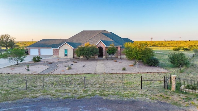 ranch-style house with a garage, concrete driveway, and fence