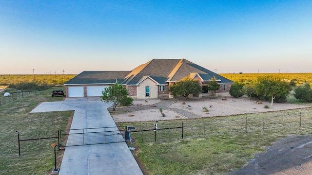 view of front facade featuring a front lawn, concrete driveway, fence, and an attached garage