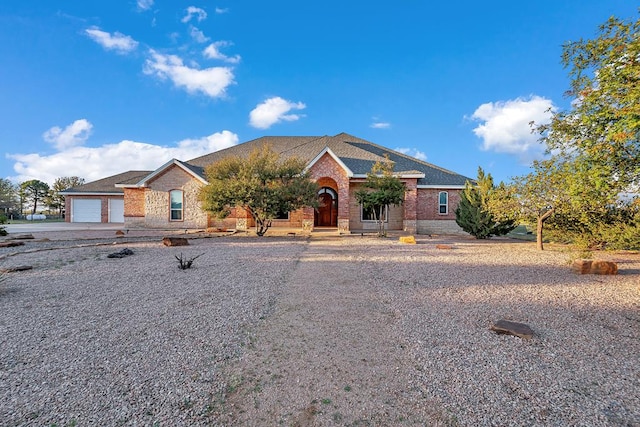 ranch-style home with a garage, concrete driveway, brick siding, and roof with shingles