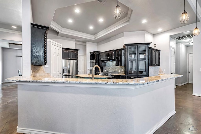 kitchen featuring a raised ceiling, stainless steel fridge with ice dispenser, glass insert cabinets, hanging light fixtures, and a peninsula