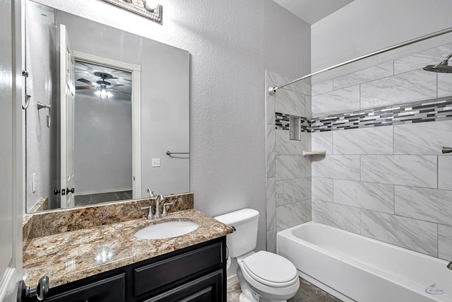 bathroom featuring a textured wall, tub / shower combination, vanity, and toilet