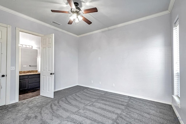 unfurnished bedroom featuring ensuite bathroom, ornamental molding, dark carpet, and visible vents