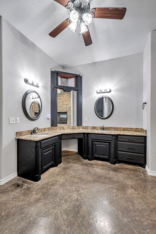 full bath with a ceiling fan, baseboards, a textured ceiling, and vanity