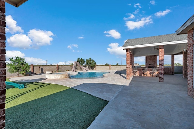 exterior space with a fenced backyard, outdoor wet bar, area for grilling, a pool with connected hot tub, and a ceiling fan