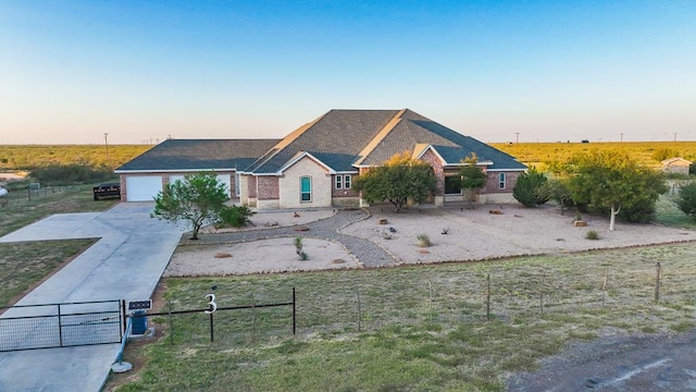 view of front of property with a gate, fence, a garage, driveway, and a front lawn