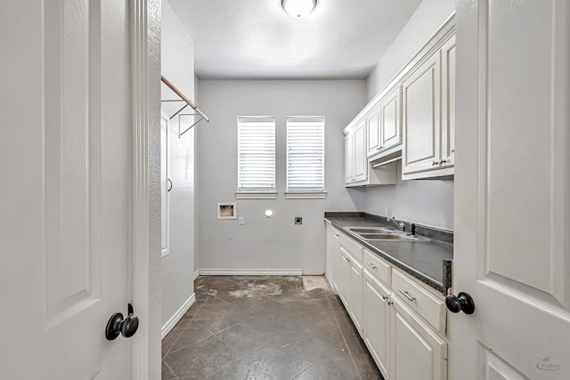 laundry room with hookup for a washing machine, hookup for an electric dryer, a sink, baseboards, and cabinet space