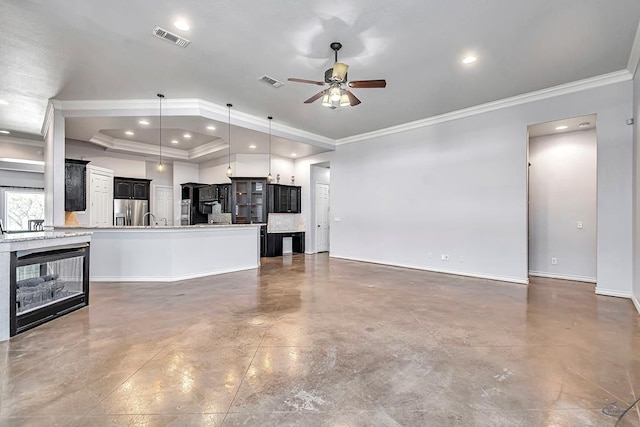 unfurnished living room featuring a tray ceiling, crown molding, recessed lighting, visible vents, and finished concrete floors