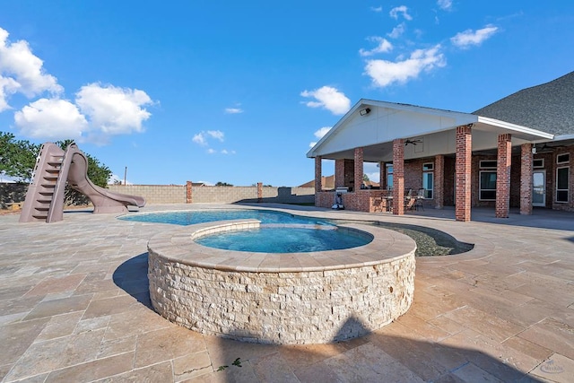 view of pool with a patio, a gazebo, ceiling fan, fence, and a water slide