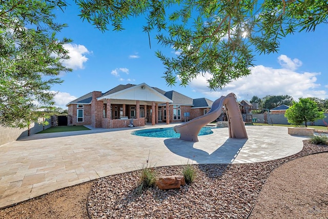 view of swimming pool featuring a fenced in pool, a water slide, fence, and a patio