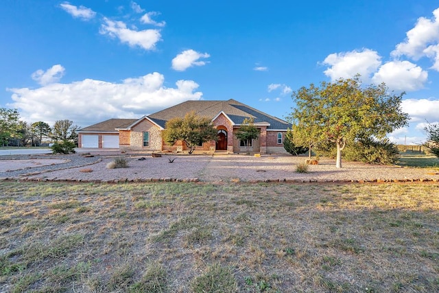 view of front of property with brick siding, a front lawn, and an attached garage