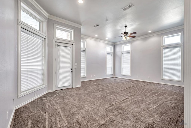 spare room featuring carpet, visible vents, and crown molding